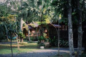 a house with palm trees in front of it at Decoco Canal-side Homestay in Ban Khlong Duang