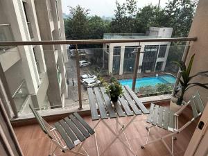 a balcony with two chairs and a swimming pool at Private Studio Apartments with Balcony in New Kalyani Nagar in Pune