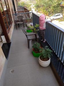 a little girl is standing on a balcony at sariska farmhouse villa in Alwar
