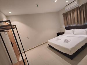 a bedroom with a bed with two towels on it at Swing & Pillows - Bukit Tinggi, Klang in Klang