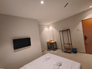 a bedroom with a bed and a flat screen tv at Swing & Pillows - Bukit Tinggi, Klang in Klang