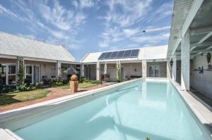 a swimming pool in the backyard of a home with a house at Hoekkraaltjie in Yzerfontein
