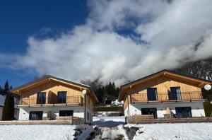 a couple of buildings in the snow at Chalets Dualhaus, 2 Apartments mit Sauna, Nähe Pressegger See, Skibus zum Nassfeld in Hermagor