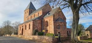 a large brick church with a tower and a tree at Ferienwohnung Nideggen, Eifel, Nähe Ruhrsee, Nationalpark in Nideggen