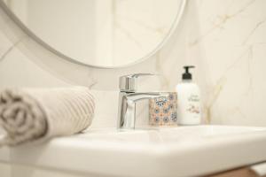 a bathroom sink with a soap dispenser and a mirror at Apartamento Terra in Benajarafe +18 photos