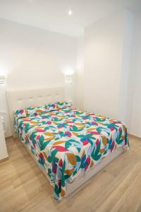 a bed with a colorful comforter in a room at Apartamento Terra in Benajarafe