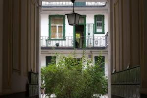 un couloir ouvert avec un bâtiment blanc doté de fenêtres vertes dans l'établissement Friendly home in the center, à Budapest