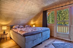 a bedroom with a bed in a room with a window at Manus Hoizhütterl in Sankt Oswald