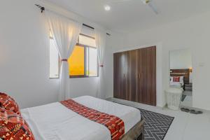 a white bedroom with a bed and a window at Wendy's Da-Azizi Homes Diani in Diani Beach +21 photos