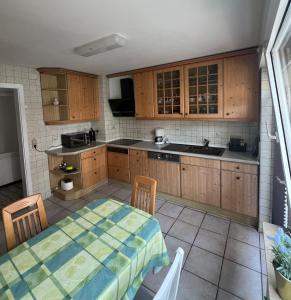 a kitchen with wooden cabinets and a table with chairs at Ferienwohnung im Täle in Bad Überkingen