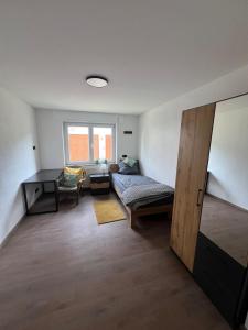 a bedroom with a bed and a desk and a window at Ferienwohnung im Täle in Bad Überkingen