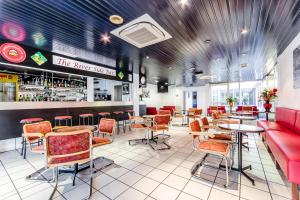 a restaurant with tables and chairs and a bar at Hôtel Arcades in Lourdes