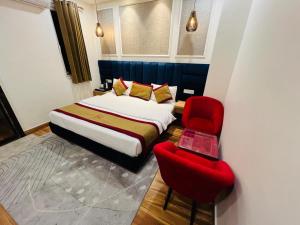 a bedroom with a bed and a red chair at Hotel Diamond Villa and Banquet in Amritsar