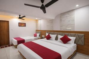 a hotel room with two beds and a ceiling fan at Hotel RK ICON in Ahmedabad +21 photos