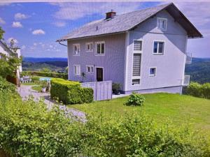 a house on top of a hill with a yard at Ferienwohnung Gabriela in Sankt Nikolai im Sausal