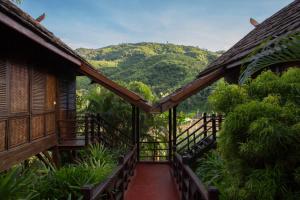 a walkway leading to a building with mountains in the background at The Luang Say Lodge in Pakbeng +44 photos