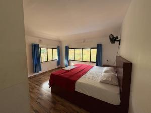 a bedroom with a large bed and two windows at FroZen NeST in Vagamon