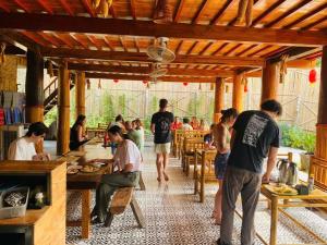 a group of people sitting at tables in a restaurant at Mai Chau Village View in Mai Châu