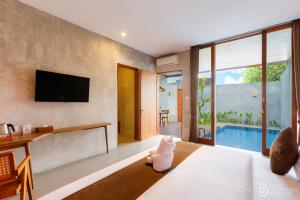 a bedroom with a television and a bed with a stuffed animal at ME Villa Pererenan in Canggu