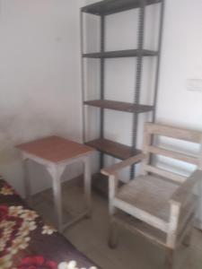a room with a chair and a ladder and a table at relief villa in Lucknow