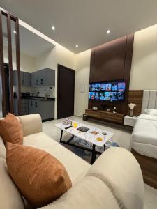 a living room with a couch and a table and a tv at Nafel Modern Suite in Riyadh