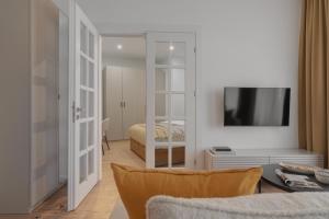 a living room with a television and a bedroom at HARBOR APARTMENTS - Mickiewicza in Katowice