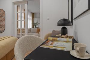 a room with a table with books and a lamp at HARBOR APARTMENTS - Mickiewicza in Katowice +51 photos