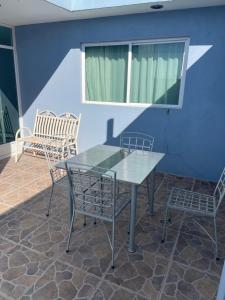 a table and chairs on a patio with a blue wall at Camino de la Plata Hotel in Fresnillo de González Echeverría