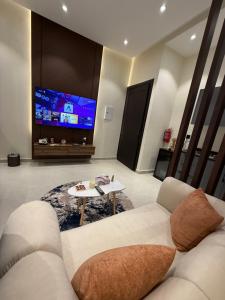 a living room with a couch and a tv at Nafel Modern Suite in Riyadh +4 photos