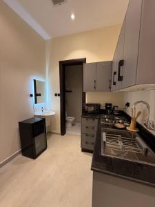 a kitchen with a sink and a stove top oven at Nafel Modern Suite in Riyadh