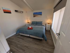 a bedroom with a bed with a red bag on it at The Flat on Muddy in Moonta