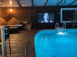 a living room with a swimming pool and a tv at La Chamade in Montjoie-en-Couserans