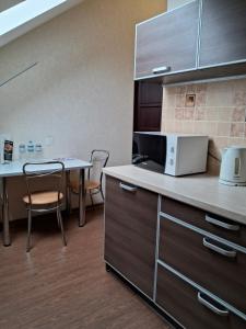 a kitchen with a table and chairs and a microwave at BavariaHotel in Kharkiv