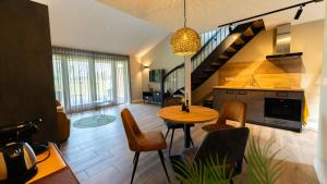 a kitchen and living room with a table and chairs at Schoapdiek Huuskes in Overdinkel