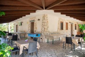 a restaurant with tables and chairs and a stone wall at B&B Parcomonsignore AGRITURISMO in San Vito dei Normanni