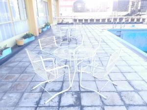 a table and chairs sitting next to a pool at Hotel Redcliff in Redcliff
