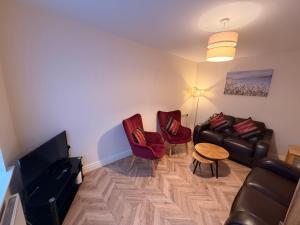 a living room with a couch and chairs and a table at The Colony Townhouse Dingle in Dingle