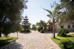 a cobblestone street with trees and a building at B&B Parcomonsignore AGRITURISMO in San Vito dei Normanni