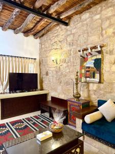 a living room with a couch and a tv at Hayat Zaman Hotel And Resort Petra in Wadi Musa