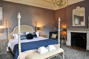 a bedroom with a bed and a fireplace and a mirror at Ash House in Wincanton