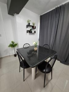 a black table and chairs in a room with a curtain at Ocean View Two Bedroom in Porlamar