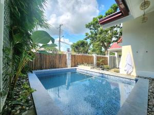 a swimming pool in a yard next to a fence at Soak Screen Urban Hideaway in Iloilo City