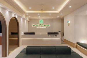 a lobby of a maruti store with a green couch in the foreground at New CZ Nampo Hotel in Busan +70 photos