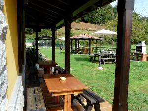 a patio with benches and tables in a park at Apartamentos El Castañeu in Corao