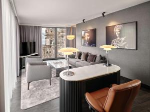 a living room with a couch and a table and chairs at Radisson Collection Hotel, Berlin in Berlin