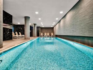 a swimming pool in a hotel with chairs at Radisson Collection Hotel, Berlin in Berlin