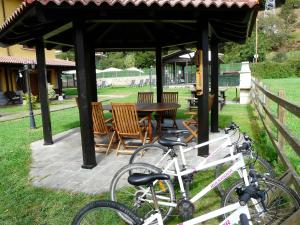 two bikes parked under a gazebo with a table and chairs at Apartamentos El Castañeu in Corao
