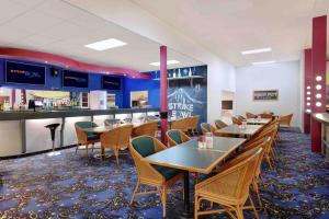 a dining room with tables and chairs and a bar at Swiss-Belresort Coronet Peak in Queenstown