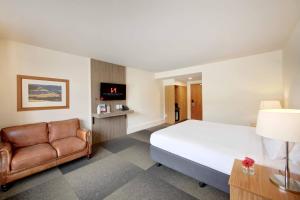 a hotel room with a bed and a chair at Swiss-Belresort Coronet Peak in Queenstown