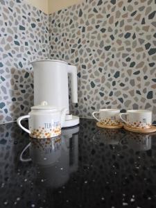 two coffee pots and saucers sitting on a table at Arashenda nest in Arashenda